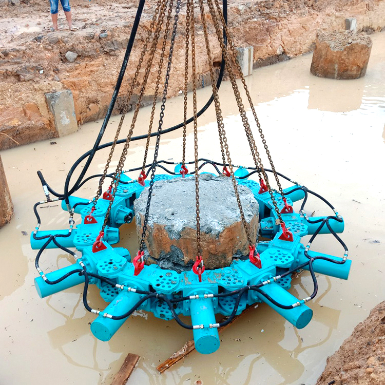 concrete pile breaker cutting round pile head in muddy construction site