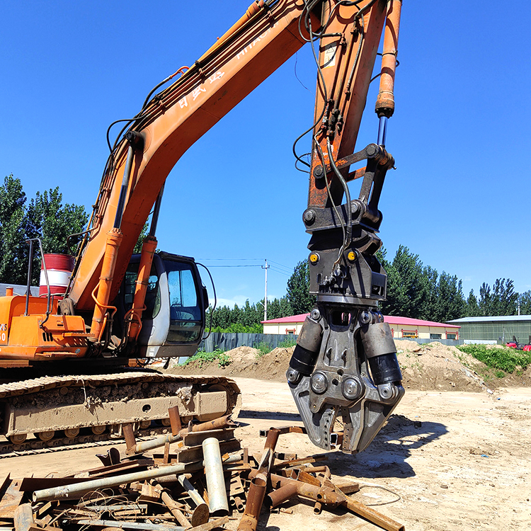 excavator hydraulic shear above scattered steel scrap on outdoor site