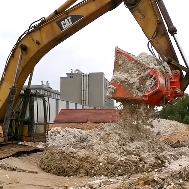 screening bucket discharging screened material on jobsite