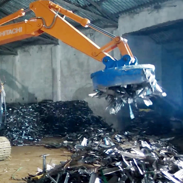 excavator electromagnet lifting scrap metal indoors