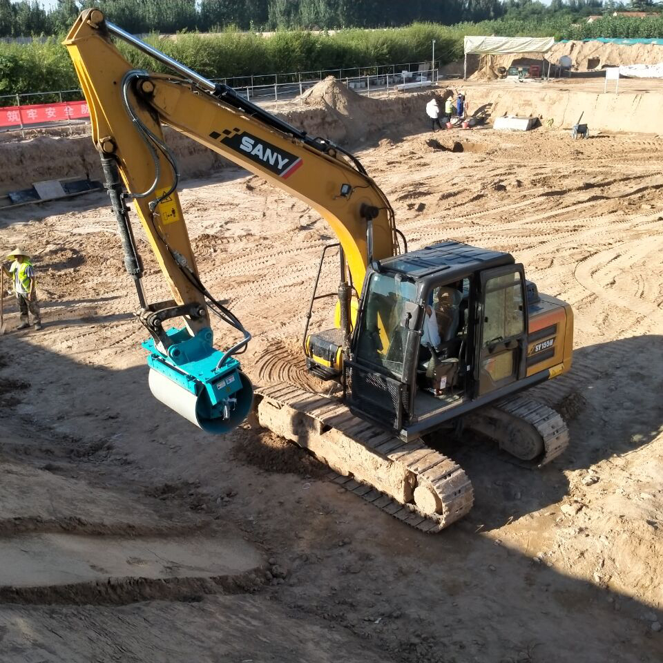 excavator drum compactor attachment working in excavation pit