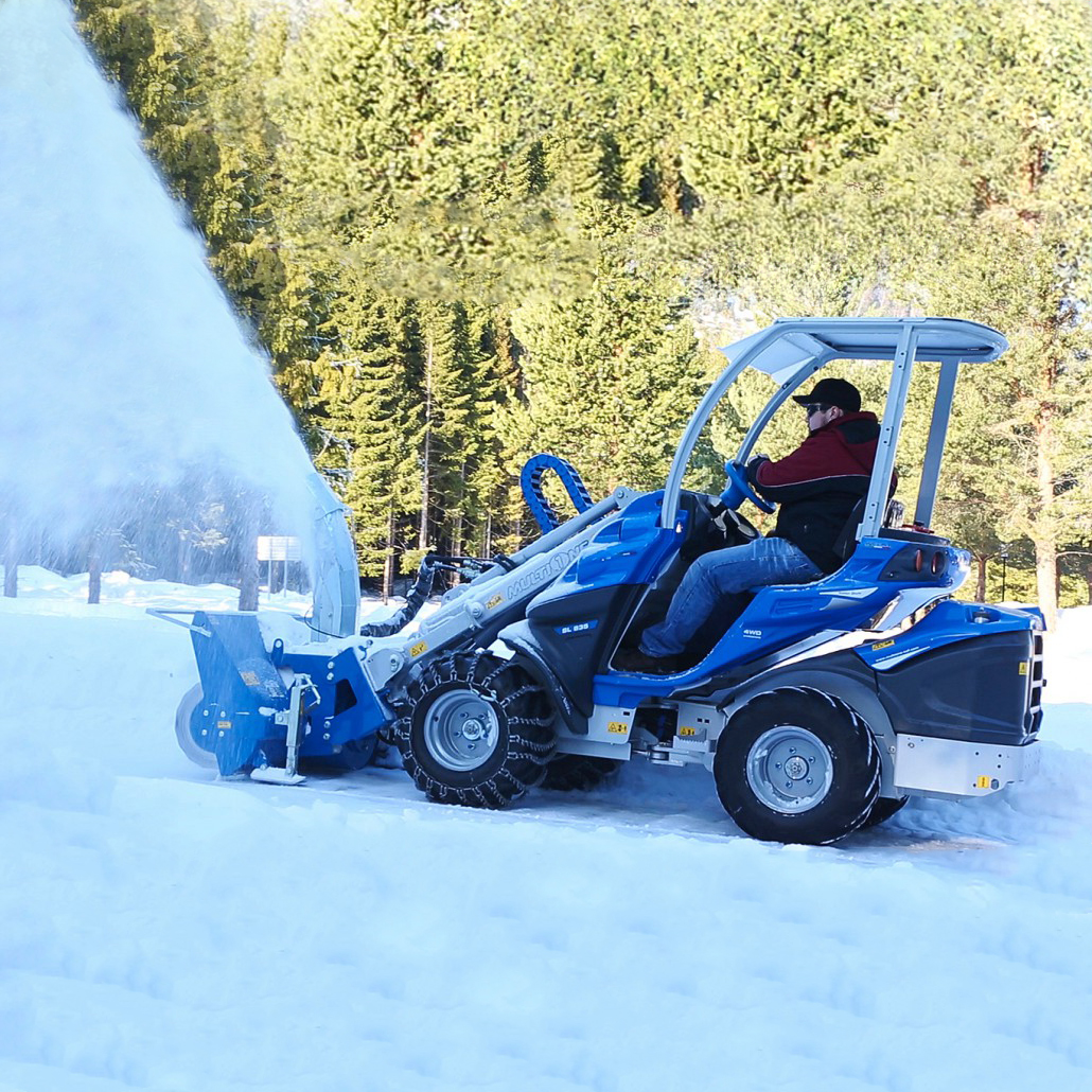 compact loader snow blower operating in roadside winter conditions