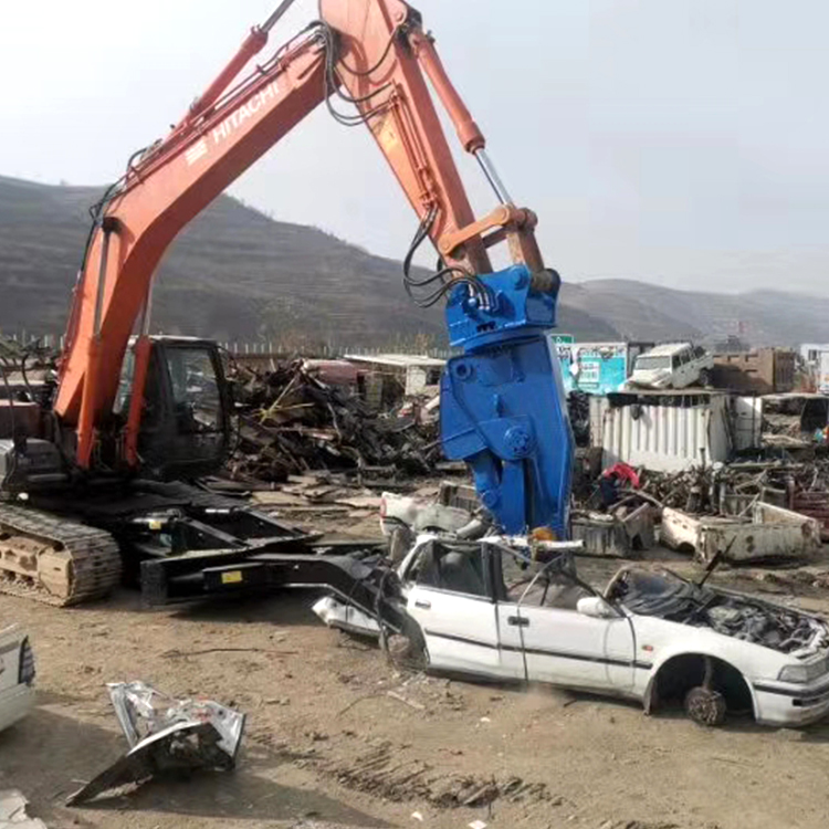 Car dismantling shear crushing a scrap car in a recycling yard