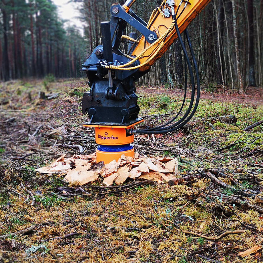excavator stump planer removing tree stump in woodland clearing
