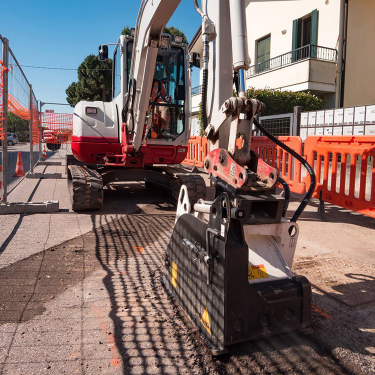 mini excavator cold planer milling asphalt beside roadway