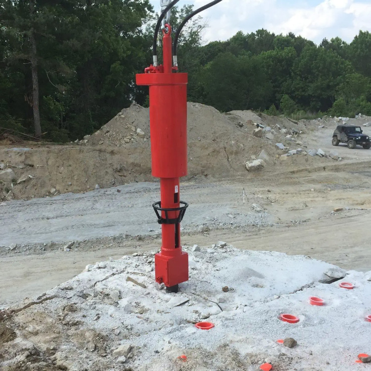 Hydraulic rock splitter breaking hard ground on construction site