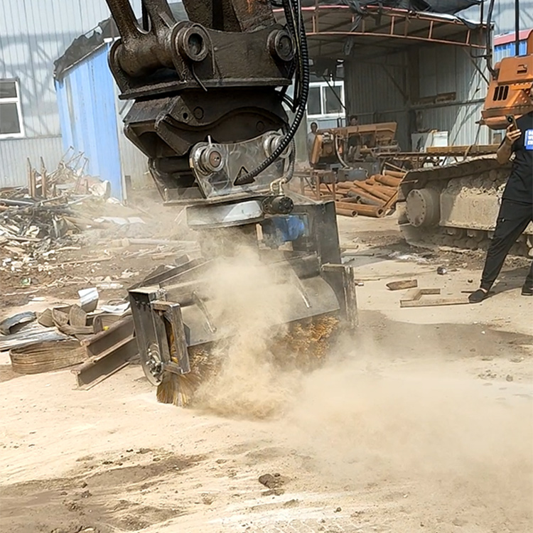 Excavator broom sweeper clearing dust on an outdoor jobsite
