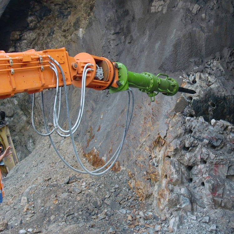 Hydraulic wedge rock splitter operating on quarry rock face