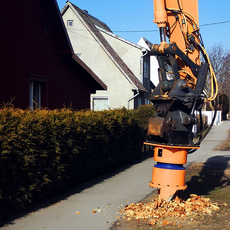 excavator stump removal attachment cutting stump beside roadside