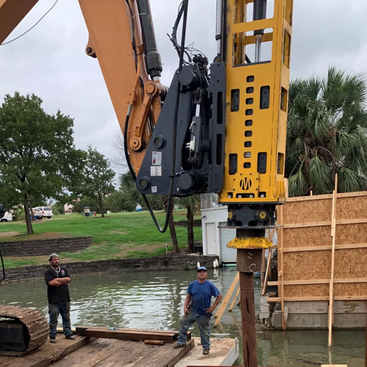Excavator mounted hydraulic impact hammer near waterfront construction