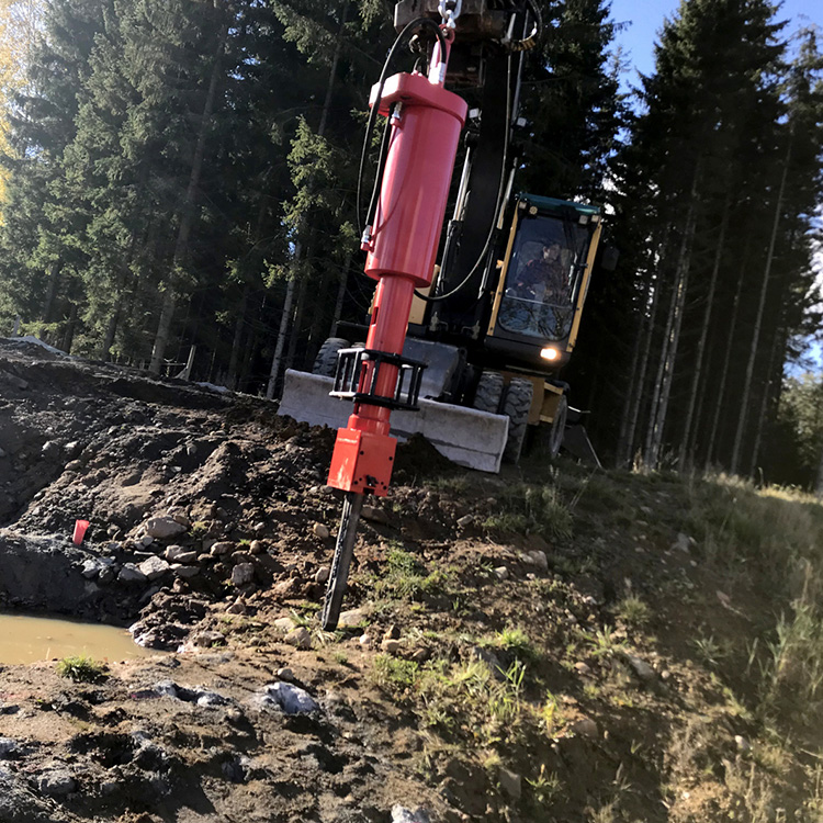 Piston rock splitter operating on rough ground outdoors