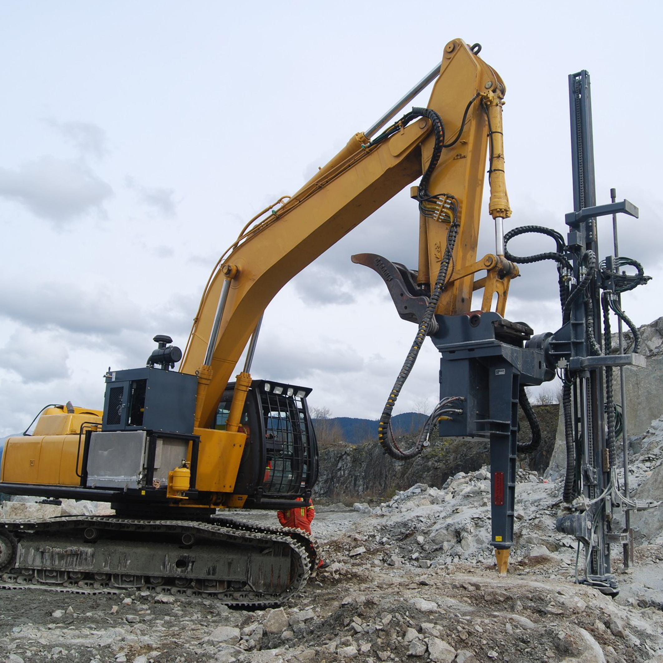 Excavator-Mounted Blast Hole Rig drilling in quarry bench area