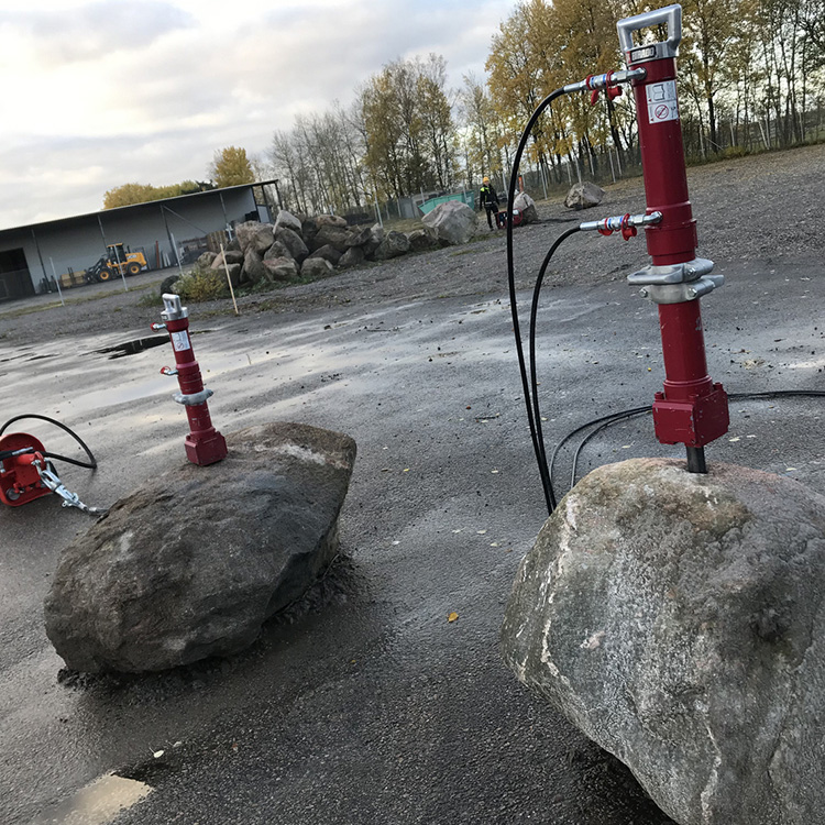 Large rock splitters installed on boulders for non-explosive splitting