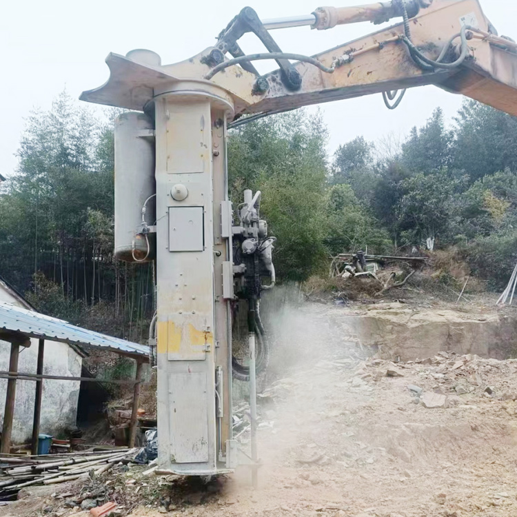 excavator rock drill splitter drilling on rock wall at job site