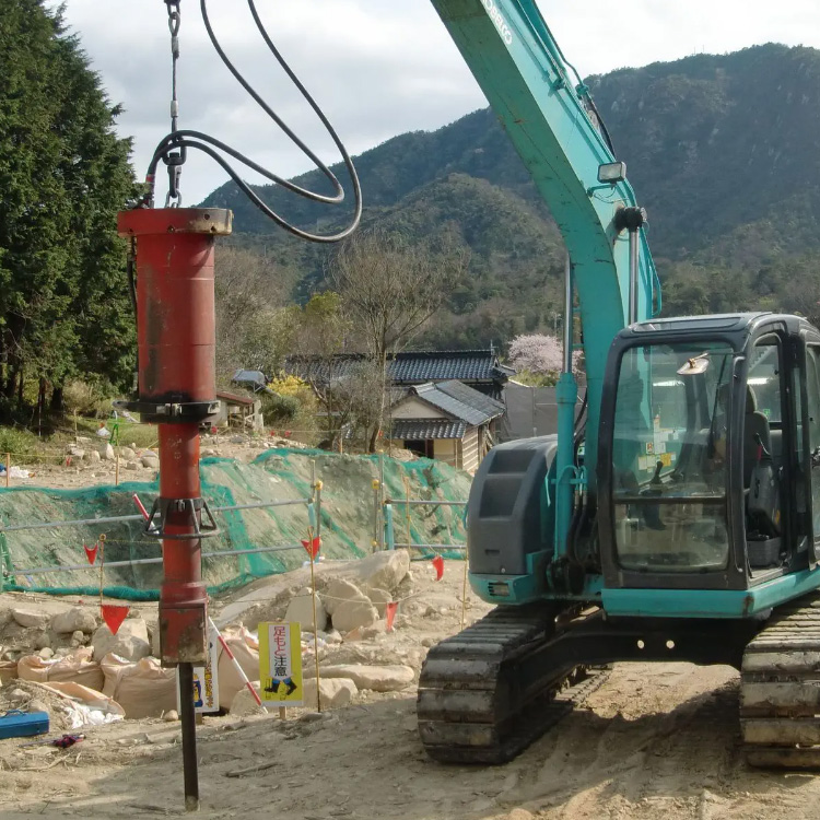 Rock splitter attachment mounted on excavator at construction site