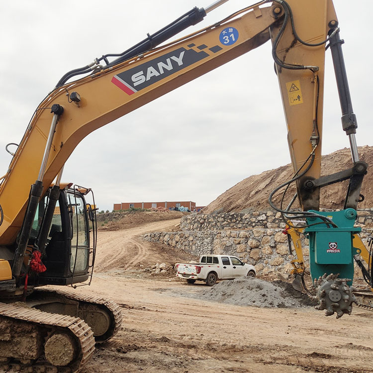 excavator with drum cutter attachment on wide jobsite view