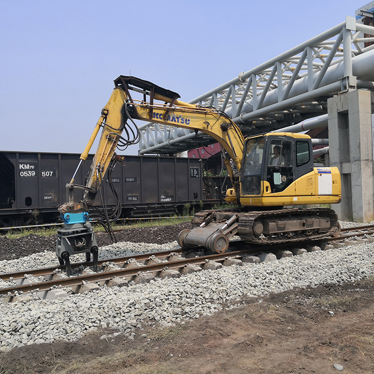excavator-mounted ballast tamper working on railway track