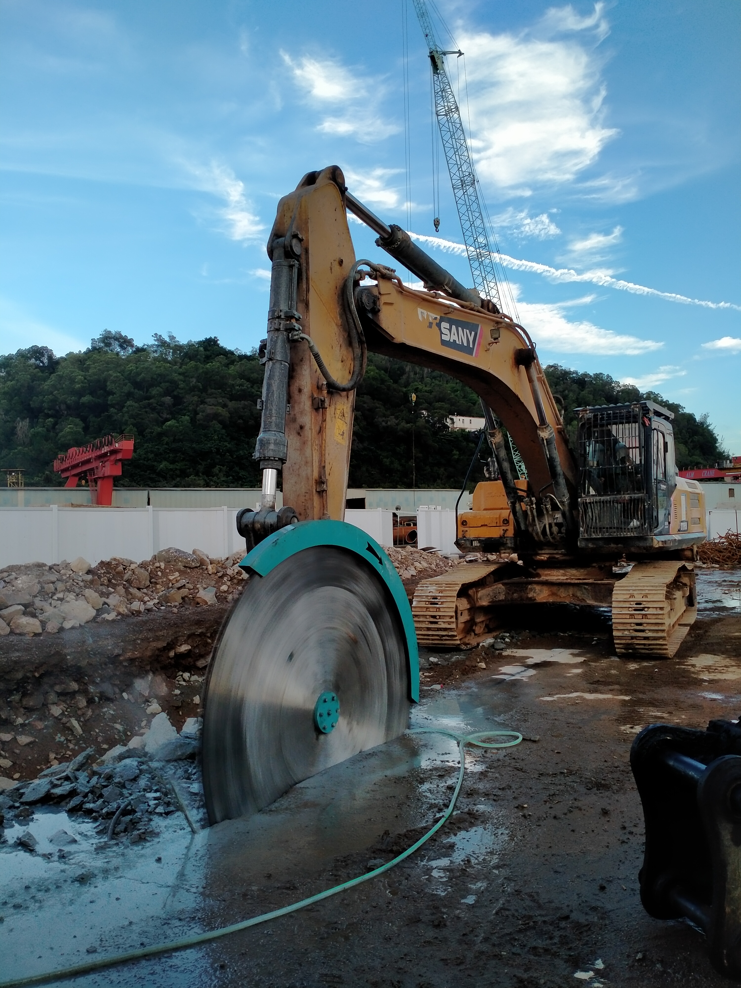 excavator rock saw cutting hard ground at jobsite