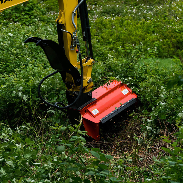 Horizontal excavator brush cutter clearing dense green vegetation close to ground